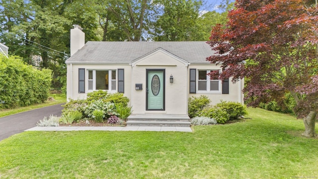 80 Holly St, Milford, CT 06460 - view of front of home featuring a chimney, a front yard, stucco siding, and a shingled roof