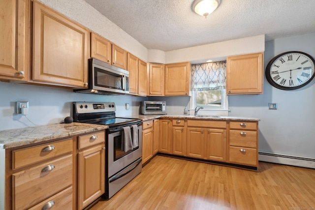 53 Daytona St, West Haven, CT 06516 - kitchen with stainless steel appliances, baseboard heating, light wood finished floors, a textured ceiling, and light brown cabinets