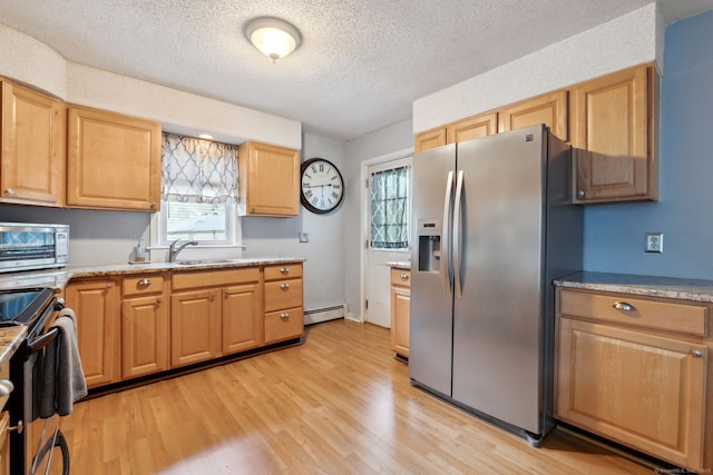 53 Daytona St, West Haven, CT 06516 - kitchen with appliances with stainless steel finishes, baseboard heating, light wood-type flooring, a textured ceiling, and light brown cabinetry