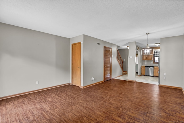 410 Emmett St Unit 45, Bristol, CT 06010 - unfurnished living room featuring light wood finished floors, a textured ceiling, and stairway
