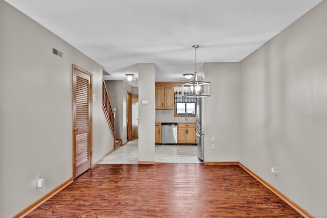 410 Emmett St Unit 45, Bristol, CT 06010 - unfurnished dining area featuring light wood-style flooring, a chandelier, and a textured ceiling