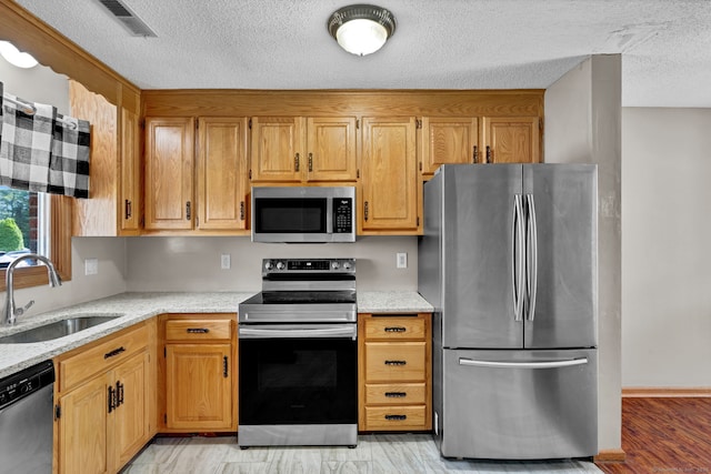 410 Emmett St Unit 45, Bristol, CT 06010 - kitchen with stainless steel appliances, a textured ceiling, and light stone counters