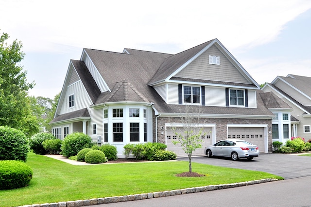 20 Carnoustie Cir, Bloomfield, CT 06002 - view of front of house with an attached garage, driveway, a front yard, and roof with shingles