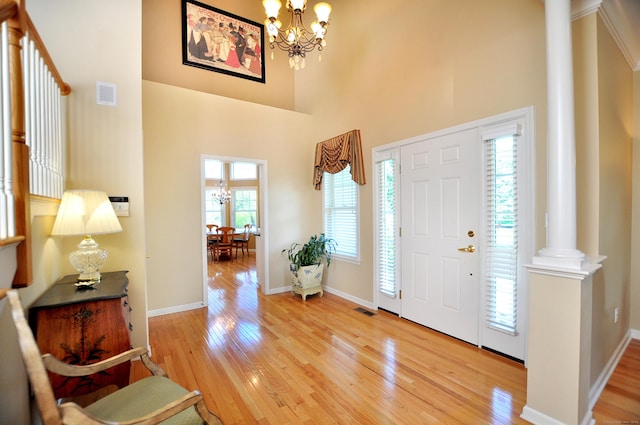 20 Carnoustie Cir, Bloomfield, CT 06002 - entrance foyer featuring ornate columns, a chandelier, light wood-style floors, and a high ceiling