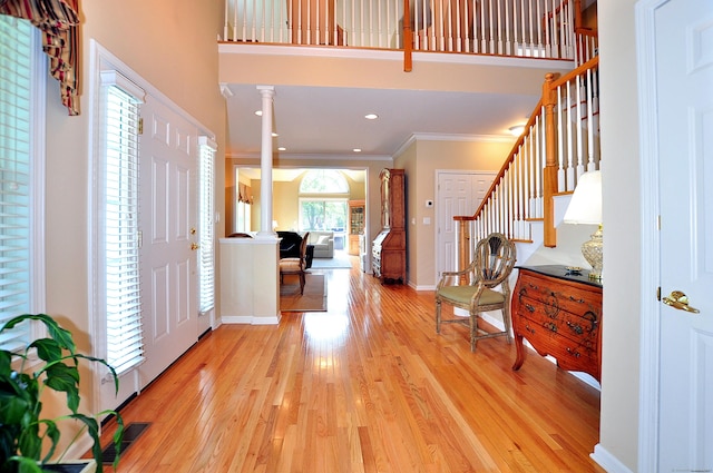 20 Carnoustie Cir, Bloomfield, CT 06002 - entrance foyer featuring stairway, crown molding, light wood-type flooring, ornate columns, and a towering ceiling
