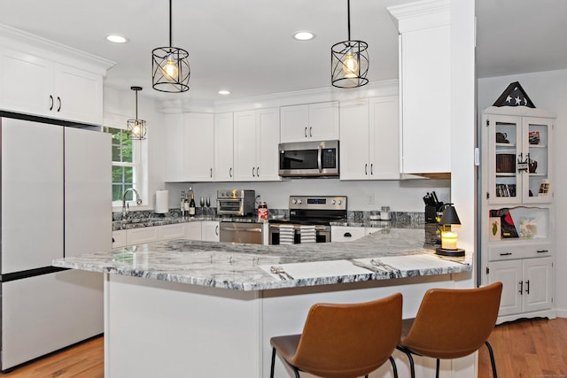6 S Bear Hill Rd, Chaplin, CT 06235 - kitchen with stainless steel appliances, light stone countertops, white cabinetry, a peninsula, and light wood-type flooring