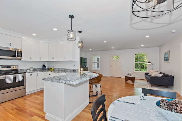 6 S Bear Hill Rd, Chaplin, CT 06235 - kitchen featuring appliances with stainless steel finishes, open floor plan, a breakfast bar area, a peninsula, and white cabinets
