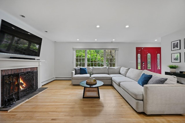 10 Eric Ct, Norwalk, CT 06851 - living room featuring a warm lit fireplace, light wood-style flooring, recessed lighting, and a baseboard heating unit