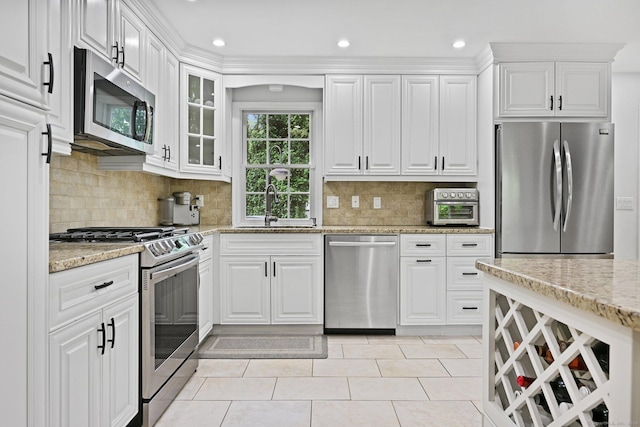 10 Eric Ct, Norwalk, CT 06851 - kitchen with appliances with stainless steel finishes, white cabinetry, light stone counters, glass insert cabinets, and recessed lighting