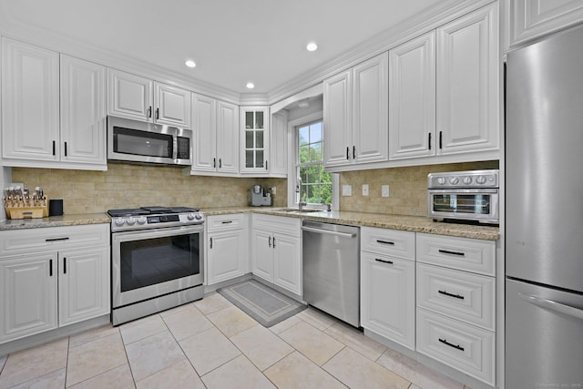 10 Eric Ct, Norwalk, CT 06851 - kitchen featuring appliances with stainless steel finishes, white cabinets, decorative backsplash, light tile patterned flooring, and recessed lighting