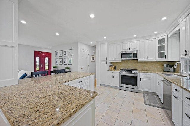 10 Eric Ct, Norwalk, CT 06851 - kitchen with stainless steel appliances, backsplash, recessed lighting, white cabinets, and light stone countertops
