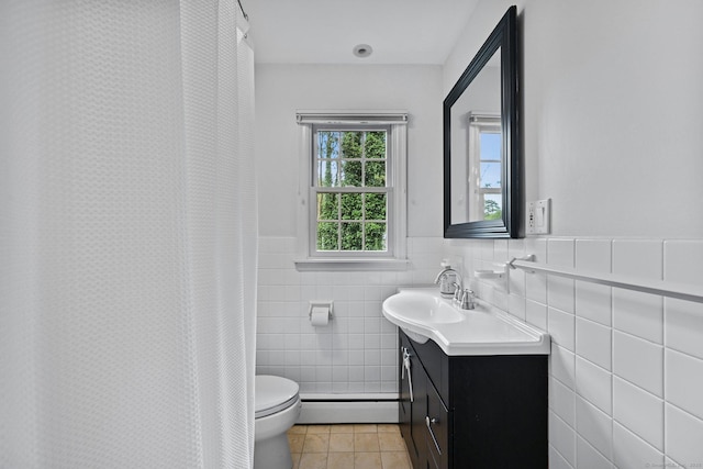 10 Eric Ct, Norwalk, CT 06851 - full bath featuring baseboard heating, tile patterned floors, vanity, tile walls, and wainscoting