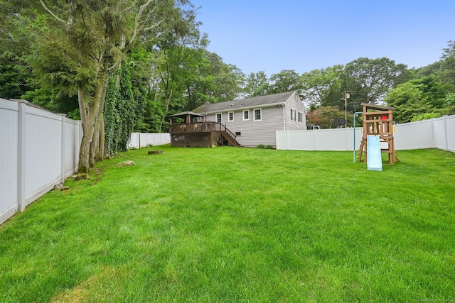 10 Eric Ct, Norwalk, CT 06851 - fenced backyard with stairs, a playground, a deck, and view of scattered trees