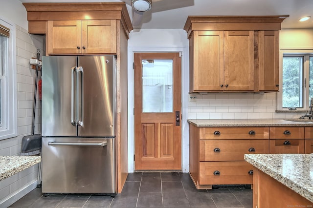 90 Edgewood Way, New Haven, CT 06515 - kitchen with high end refrigerator, light stone counters, decorative backsplash, dark tile patterned floors, and brown cabinets