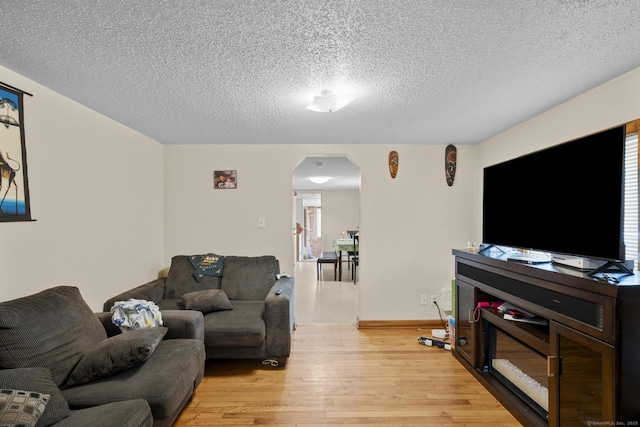 52 Colony St, Bristol, CT 06010 - living area with arched walkways, light wood-type flooring, and a textured ceiling