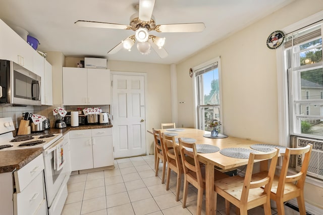 17 Pleasant St, Danbury, CT 06810 - kitchen with stainless steel microwave, white range with electric stovetop, dark countertops, and plenty of natural light