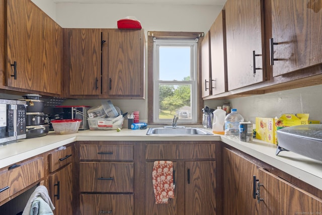 53 Norton St, Bristol, CT 06010 - kitchen with light countertops, stainless steel microwave, and brown cabinetry