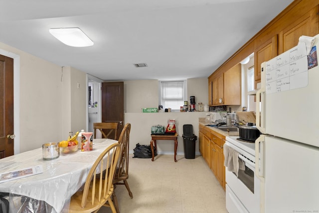 53 Norton St, Bristol, CT 06010 - kitchen featuring white appliances, brown cabinets, light floors, light countertops, and healthy amount of natural light