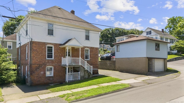 53 Norton St, Bristol, CT 06010 - view of front of home featuring brick siding, concrete driveway, a garage, and a chimney
