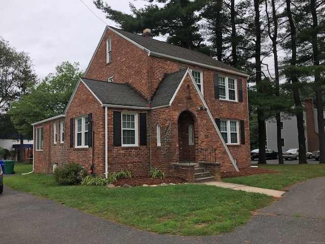 1333 Blue Hills Ave, Bloomfield, CT 06002 - tudor home with brick siding, a front yard, roof with shingles, and a chimney
