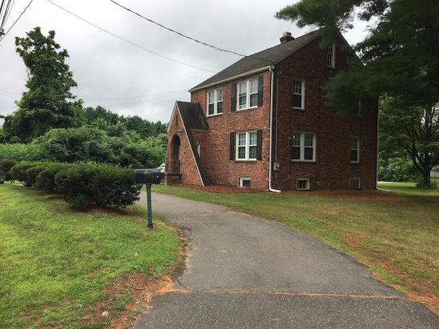 1333 Blue Hills Ave, Bloomfield, CT 06002 - view of home's exterior with brick siding, a lawn, a chimney, and asphalt driveway