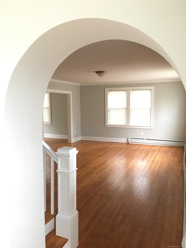 1333 Blue Hills Ave, Bloomfield, CT 06002 - empty room featuring arched walkways, a baseboard heating unit, crown molding, and wood finished floors