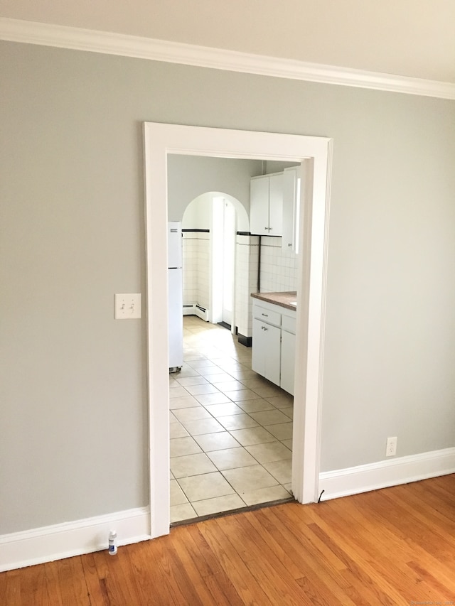 1333 Blue Hills Ave, Bloomfield, CT 06002 - empty room with baseboard heating, crown molding, arched walkways, and light wood finished floors