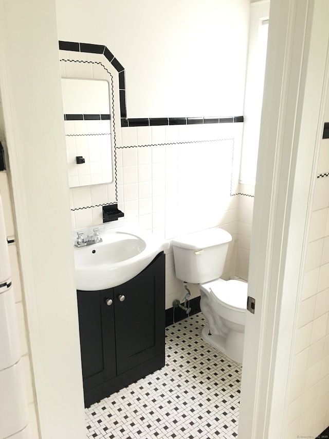 1333 Blue Hills Ave, Bloomfield, CT 06002 - half bath featuring vanity, tile walls, tile patterned flooring, and wainscoting