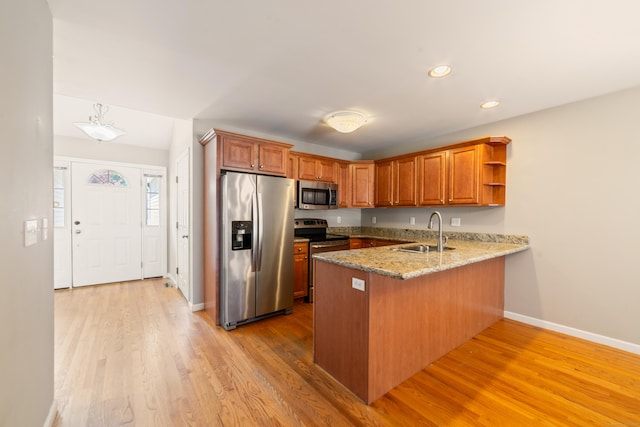 44 Forshaw Ave Unit 44, Plainville, CT 06062 - kitchen with stainless steel appliances, a peninsula, open shelves, light wood-style flooring, and brown cabinetry