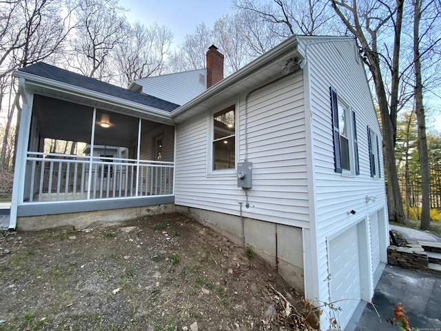 545 Simsbury Rd, Bloomfield, CT 06002 - view of home's exterior featuring a garage, a chimney, a sunroom, and a shingled roof