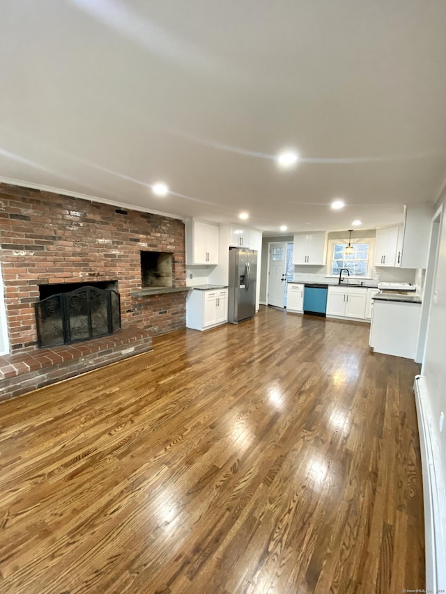 545 Simsbury Rd, Bloomfield, CT 06002 - unfurnished living room with dark wood-type flooring, a brick fireplace, and recessed lighting