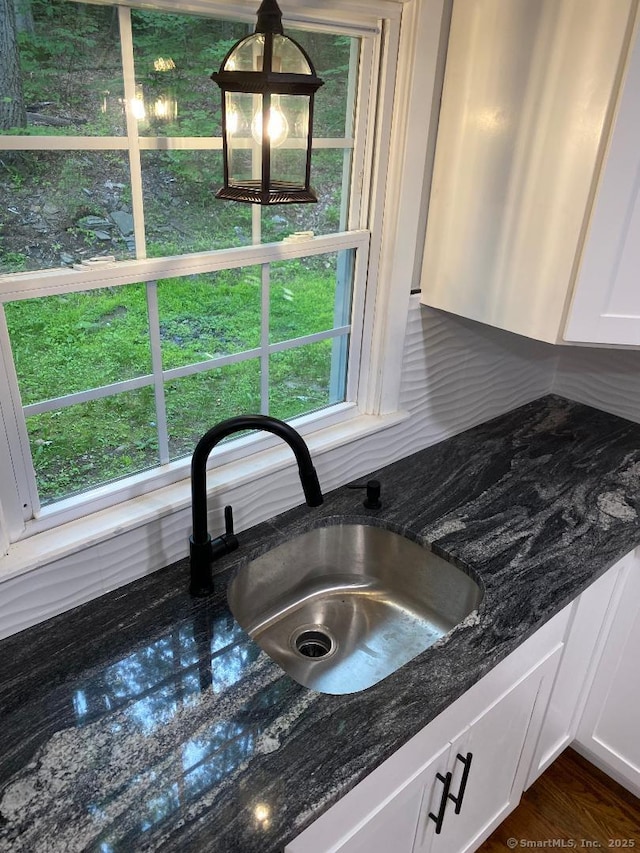 545 Simsbury Rd, Bloomfield, CT 06002 - kitchen view of white cabinetry, decorative backsplash, dark stone counters, and decorative light fixtures