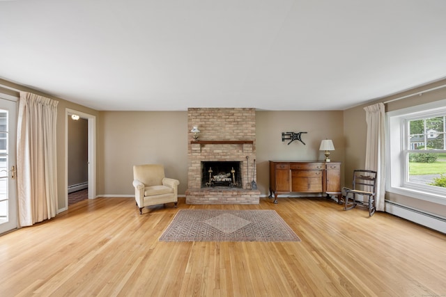1519 Tuttle Ave, Wallingford, CT 06492 - living area with wood finished floors, a brick fireplace, and a baseboard radiator