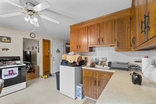 6 Houghton St, Bristol, CT 06010 - kitchen with white electric range oven, washer / dryer, light countertops, brown cabinets, and tasteful backsplash