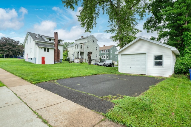 546 S Quaker Ln, West Hartford, CT 06110 - back of property with a detached garage, asphalt driveway, a lawn, an outdoor structure, and a residential view