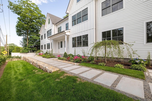 133 E Ave Unit A, New Canaan, CT 06840 - view of front facade with board and batten siding and a front yard