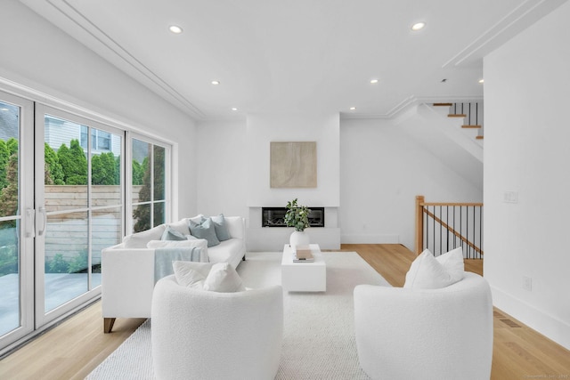 133 E Ave Unit A, New Canaan, CT 06840 - living room with recessed lighting, light wood finished floors, a glass covered fireplace, and stairway