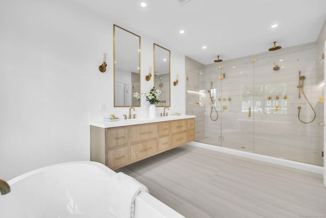 133 E Ave Unit A, New Canaan, CT 06840 - bathroom featuring a shower stall, double vanity, a freestanding tub, and recessed lighting