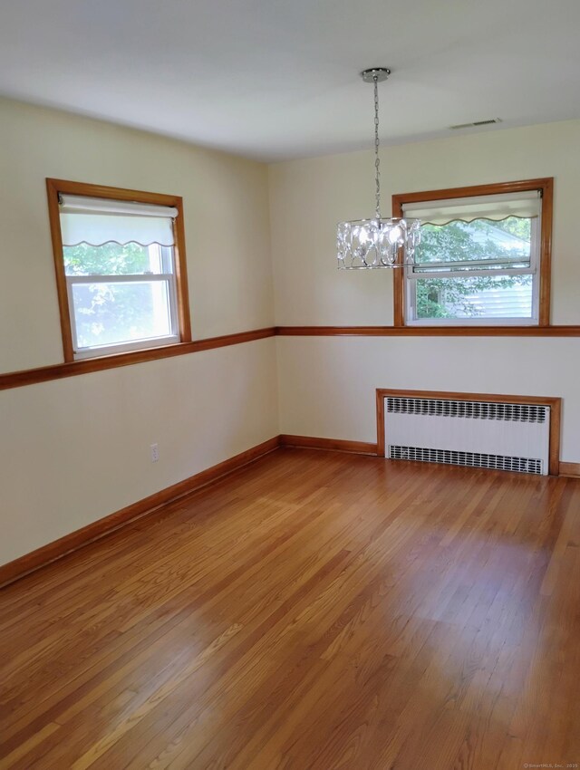 3 Rye Ridge Parkway, West Hartford, CT 06117 - empty room featuring radiator, wood finished floors, and a chandelier