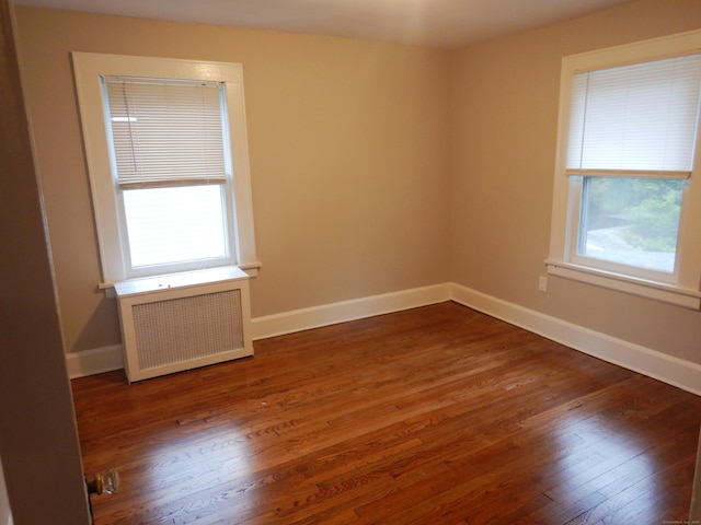 11 Morton St, New London, CT 06320 - unfurnished room featuring radiator heating unit, plenty of natural light, and wood finished floors