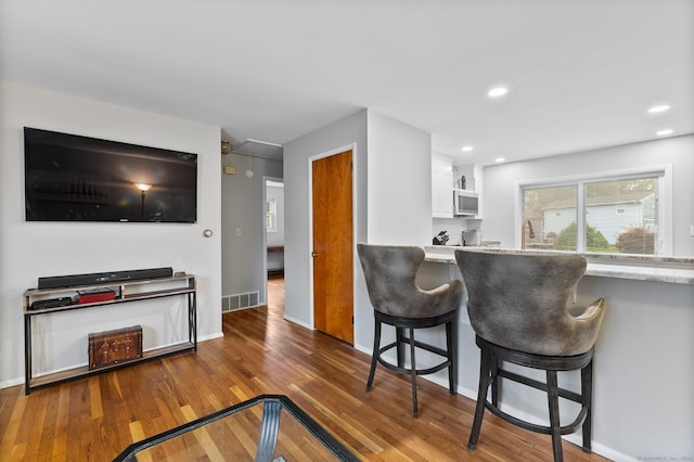 301 Pondview Dr, Southington, CT 06489 - kitchen with wood finished floors, white cabinetry, a breakfast bar area, and recessed lighting