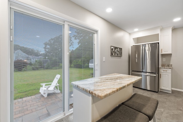 301 Pondview Dr, Southington, CT 06489 - kitchen with freestanding refrigerator, white cabinetry, light stone counters, recessed lighting, and a kitchen island