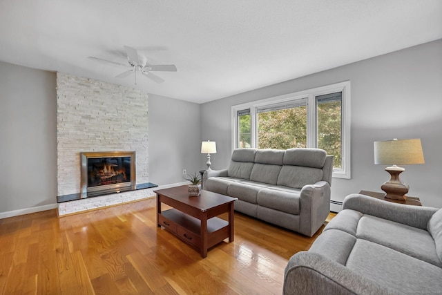 142 Raffia Rd, Enfield, CT 06082 - living room featuring a ceiling fan, wood finished floors, a stone fireplace, and a baseboard heating unit