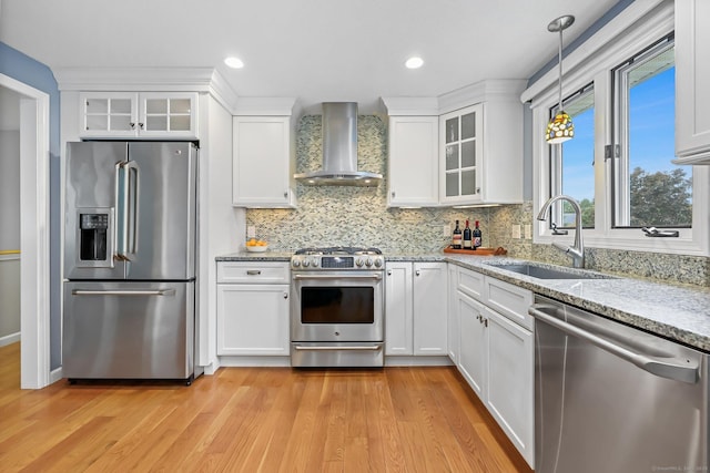 142 Raffia Rd, Enfield, CT 06082 - kitchen featuring appliances with stainless steel finishes, wall chimney range hood, white cabinetry, light wood-style floors, and recessed lighting