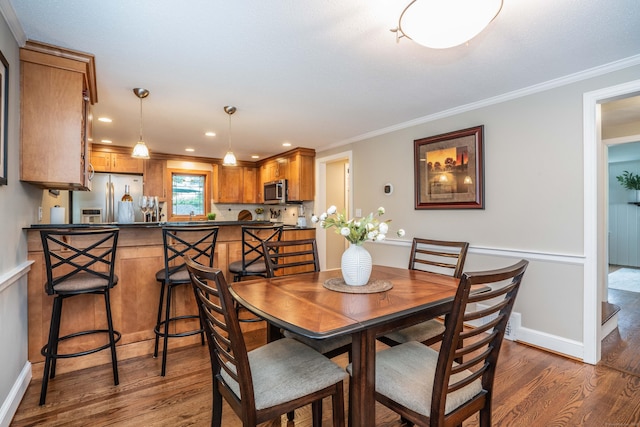 11 Craigmoor Rd, West Hartford, CT 06107 - dining area with dark wood-style flooring, ornamental molding, and recessed lighting