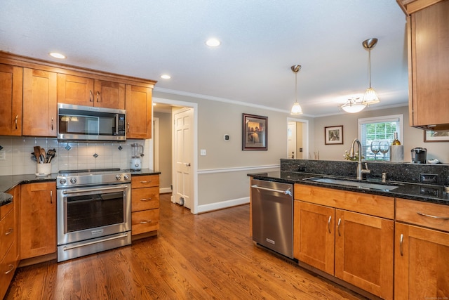 11 Craigmoor Rd, West Hartford, CT 06107 - kitchen with appliances with stainless steel finishes, brown cabinetry, crown molding, wood finished floors, and decorative backsplash