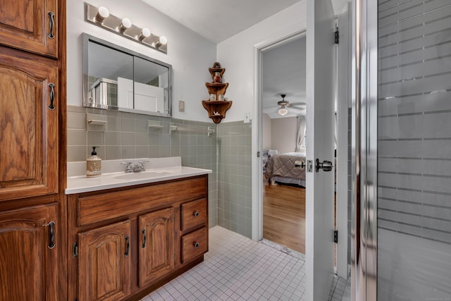 112 Shadow Ln, West Hartford, CT 06110 - ensuite bathroom featuring tile walls, vanity, a ceiling fan, tile patterned floors, and wainscoting