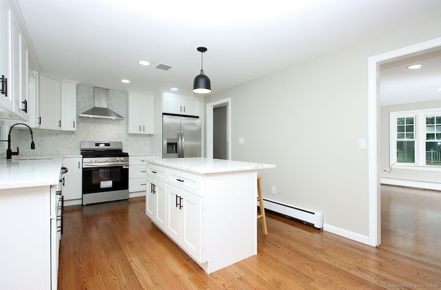 5 Great Meadow Dr, North Haven, CT 06473 - kitchen with stainless steel appliances, wall chimney exhaust hood, baseboard heating, light wood-type flooring, and decorative backsplash