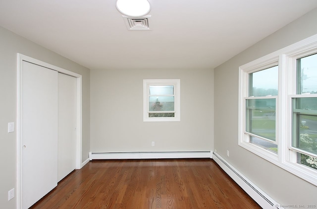 5 Great Meadow Dr, North Haven, CT 06473 - unfurnished bedroom with a baseboard heating unit, dark wood-type flooring, and a closet
