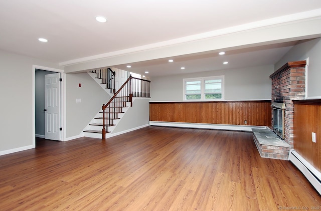 5 Great Meadow Dr, North Haven, CT 06473 - unfurnished living room featuring wood finished floors, a brick fireplace, stairway, a baseboard heating unit, and recessed lighting